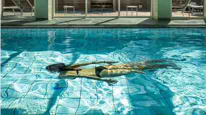 A woman is swimming in the pool