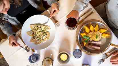 Two people are eating typical South Tyrolean dishes