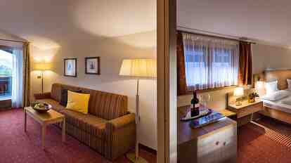 Suite Charme St. Anton mit Doppelbett, Wohnbereich, Sofa, Schreibtisch und Balkonzugang.
